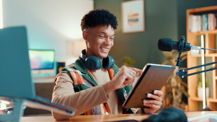 Man, streamer and tablet in home with mic, typing and smile with script editing for video production. Influencer, happy and app for chat with fans, click or subscription list on social media at house