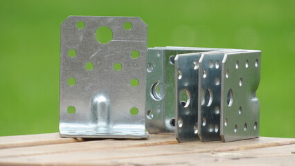 Metal brackets on wooden surface under natural lighting suitable for construction and assembly...