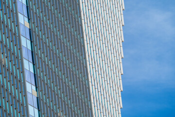 Contemporary Skyscraper Corner Detail with Diamond Pattern Glass Facade Against Blue Sky
