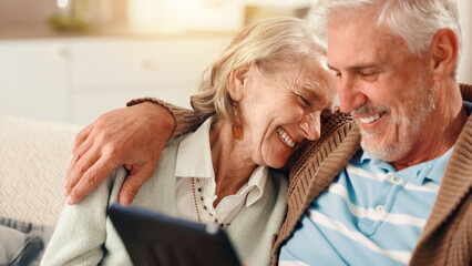 Senior couple, tablet and laugh on sofa in home with hug, happy and relax with film in living room....