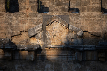 Part of the stone wall of the ancient amphitheater with architectural elements.