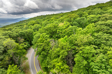 Naklejka premium Road trip driving in Tennessee Appalachian mountains. Winding parkway in mountain forest with green canopies in summer rain season