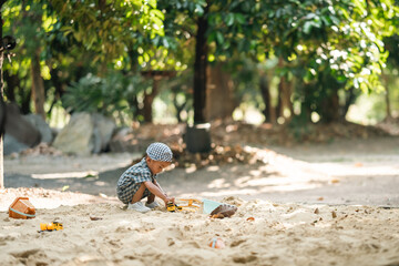 Curious toddler playing with sand outdoors, developing fine motor skills, creativity, and cognitive growth through hands-on exploration in a safe, natural learning environment under sunlight