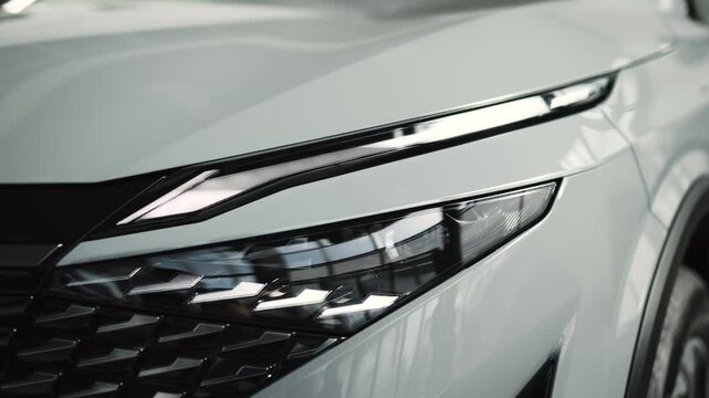 Close-up of car headlights in an automobile showroom. An advanced design concept that improves visibility, demonstrates innovation and adds style to nighttime driving.