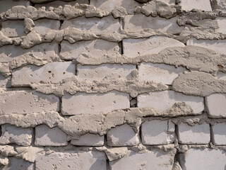 A wall made of white bricks with a rough texture