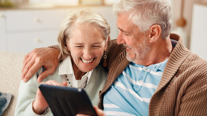 Senior couple, tablet and happy on sofa in home with hug, laughing and relax with film in living...