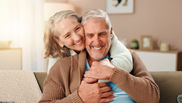 Senior woman, man and hug on sofa with smile, care and bonding with love in retirement in lounge. Elderly people, couple and embrace with trust, loyalty and happy marriage in living room at house