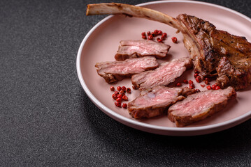 Juicy meat on the bone or rack of lamb. Grilled veal with salt, spices and herbs