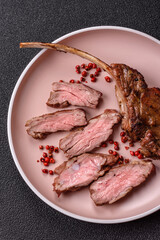 Juicy meat on the bone or rack of lamb. Grilled veal with salt, spices and herbs