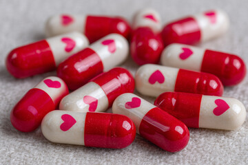 red and white capsule pills with heart print, love drug themes