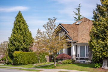 Two story stucco luxury house with nice spring blossom landscape in Vancouver, Canada, North America. Day time on May 2025.