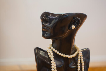 Vintage black female figurine with pearls and pearl necklace.