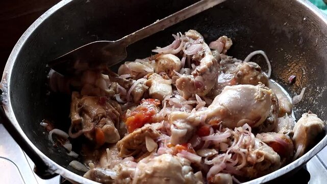 Delicious Irani Chicken Karahi (Kadai Bhuna) curry stirred with spatula in home kitchen. Close-up of hot, spicy Iranian chicken kadhai cooking, savory and appetizing.