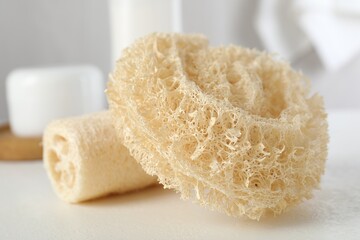 Different loofah sponges on white table, closeup