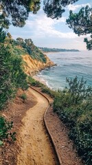 Scenic coastal trail with lush greenery sandy beach cliffs ocean view and blue sky perfect for outdoor adventure nature travel and relaxation