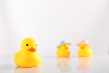 Cute rubber ducks on white background, selective focus. Space for text