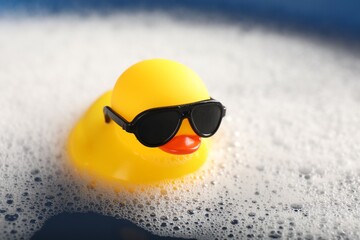 Obraz premium Cute rubber duck floating in water with bubbles, closeup