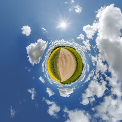 simple little tiny planet without buildings in blue sky with sun and beautiful clouds. Transformation of spherical panorama 360 degrees. Spherical abstract aerial view. Curvature of space.
