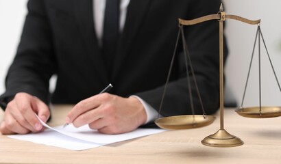 Judge working and scales on desk indoors, selective focus