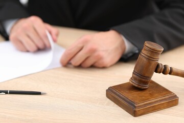 Judge working and gavel on desk indoors, selective focus