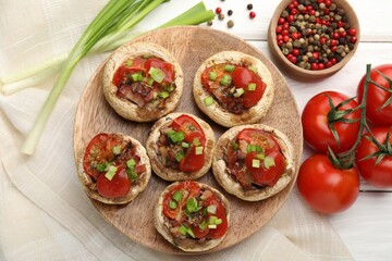 Tasty stuffed mushrooms served on white wooden table, flat lay