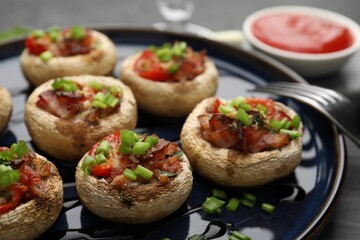 Tasty stuffed mushrooms served on black table, closeup