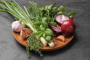Different herbs and spices on black table, closeup
