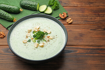 Tasty cucumber soup with croutons and broccoli on wooden table, closeup. Space for text