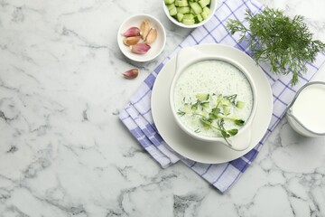Tasty cucumber soup with dill, microgreens and ingredients on white marble table, flat lay. Space for text