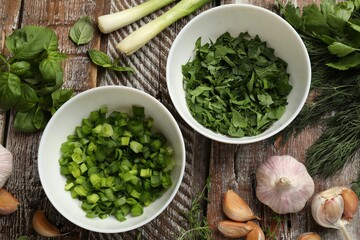Different fresh herbs and spices on wooden table, flat lay