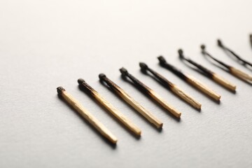 Burnt matches on grey background, closeup view