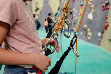 Young girl attached to rock climbing equipment