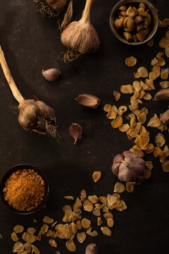 Garlic cloves and chips on dark surface