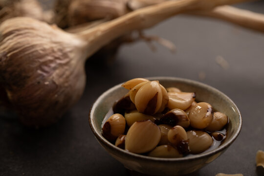 Garlic bulb with cloves on dark benchtop