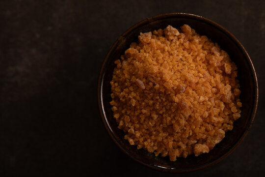 Garlic salt in bowl on dark surface