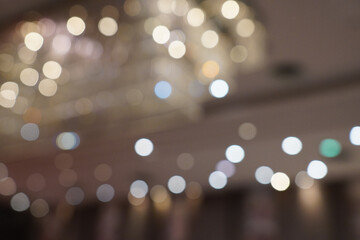 Abstract bokeh background with blurred lights in gold and beige tones. Bokeh background with bright...