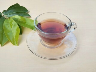 cup ofSoursop leaf boiled water in glass on wooden table, high angle view. Healthy drink lifestyle 