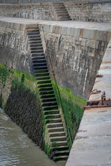 Port-en-Bessin-Huppain, France - 05 15 2025: Graphical view of the harbor, the pier stone...