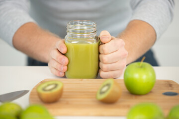 male athlete making juice or smoothie in kitchen