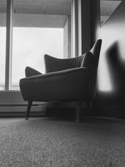 Un fauteuil dans une salle d'attente. Image en noir et blanc.