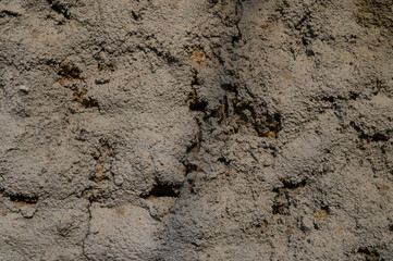 Rough and aged concrete wall surface with cracks and stains. Perfect for use as a textured background or design element.