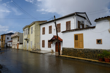 Typical Cypriot street during a light rain shower, stone pavement and white walls glistening from moisture.