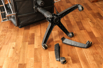 office chair on the floor with broken legs: a symbol of poor workmanship and the need for repairs.