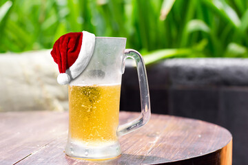 Santa Claus Hat on glass of beer on table. Christmas and New Year celebration