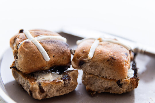 buttered hot cross buns on a plate