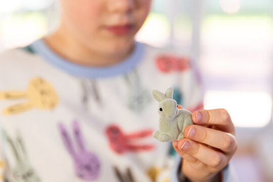 child holding a bunny figurine in his fingertips