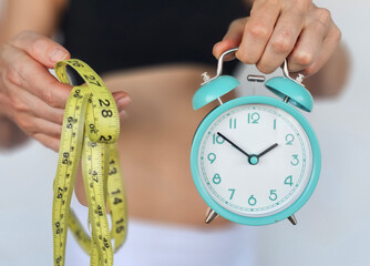 Time management and health tracking with a clock and measuring tape in a fitness