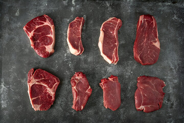 Various Cuts of Raw Beef on Dark Background – Butcher Meat Selection


