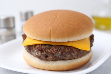 Cheeseburger with tasty patty on white table, closeup