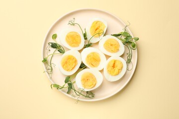 Boiled eggs and microgreens on beige background, top view